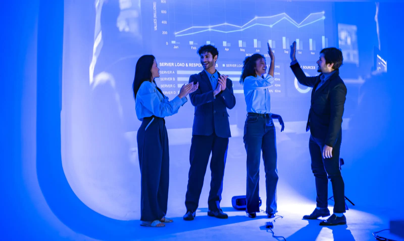 IT support team celebrating in front of a data display